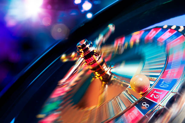 rueda de ruleta en movimiento con un fondo colorido y bien - gambling fotografías e imágenes de stock