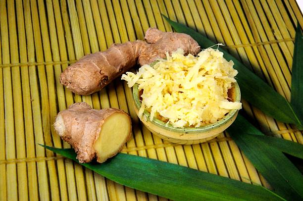 Pieces of root ginger with some grated in a dish.