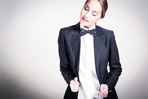Portrait of beautiful young woman in man's suit with bowtie