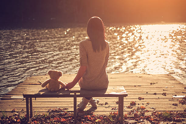 istock Woman and teddy bear sitting bench 537213689
