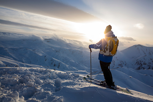 Freerider skier on top of ski slope  at sunset