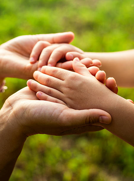 istock Child's hands in palms of mother's hands 537232666