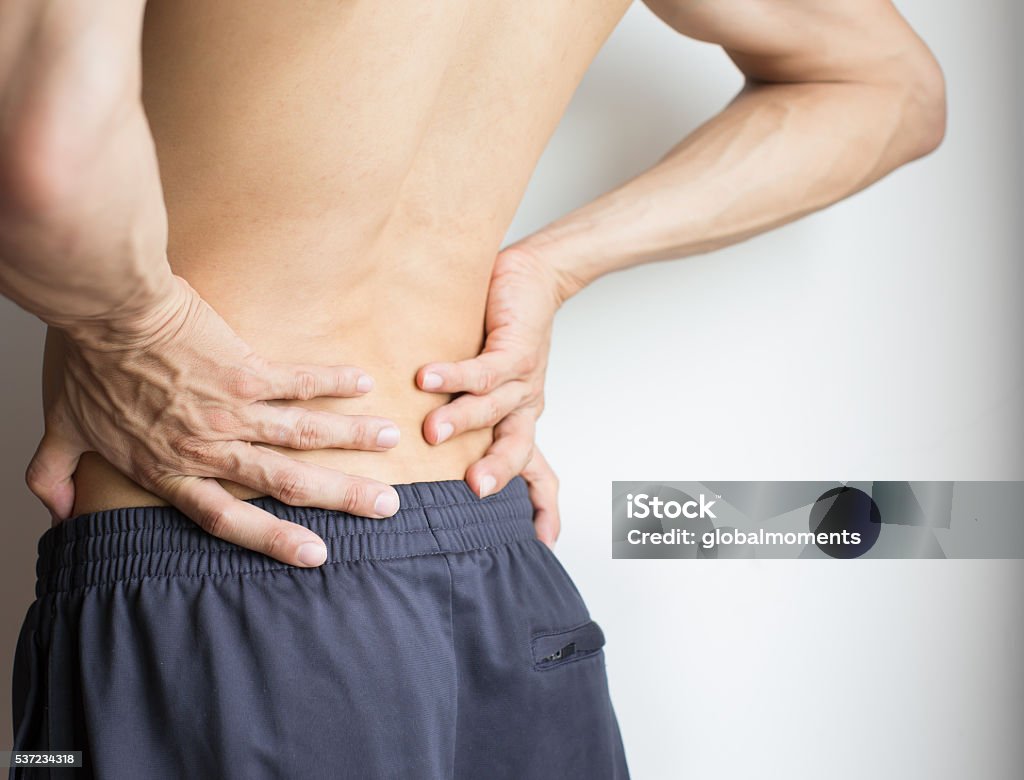 Uomo che si tocca la schiena a causa di un forte mal di schiena - Foto stock royalty-free di Dolore fisico