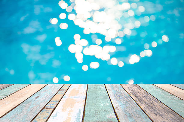 istock Wood table top and blurry blue water bokeh abstract background 537238590