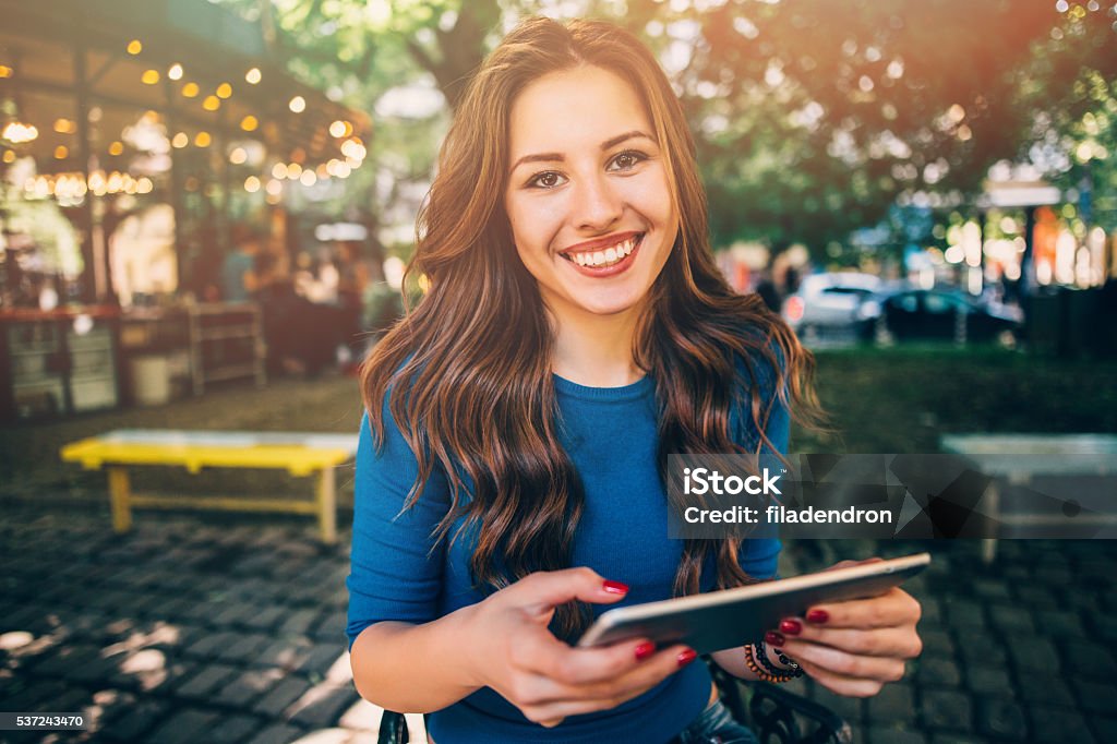 Young lady at the cafe Young lady using a tablet at the cafe. Laughing Stock Photo