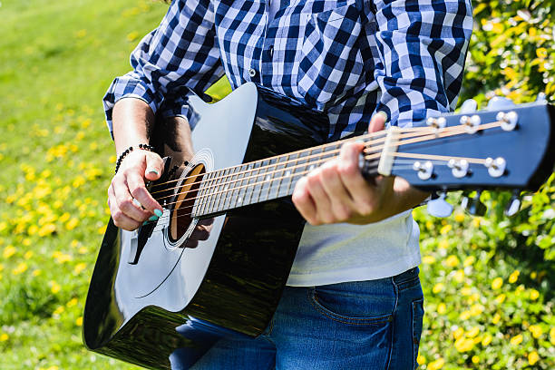 istock girl on a green meadow playing guitar 537247354