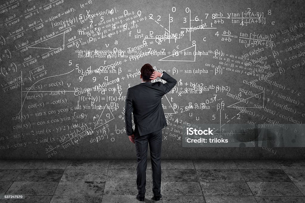 Businessman solving mathematical equation Rear view of pensive businessman scratching his head and looking at mathematical equation on wall Mathematical Formula Stock Photo