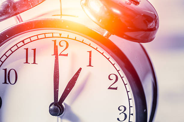 istock closeup vintage clock focus at 1 o'clock with sun light 537249370