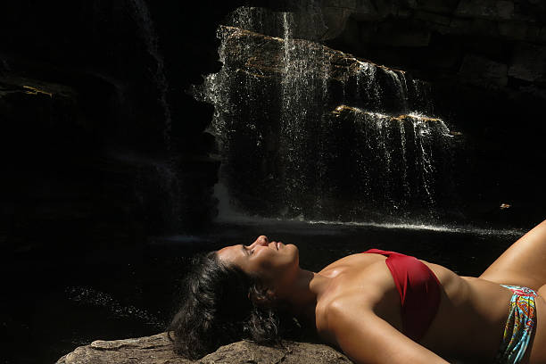 istock Woman sunbathing by the waterfall. 537249437