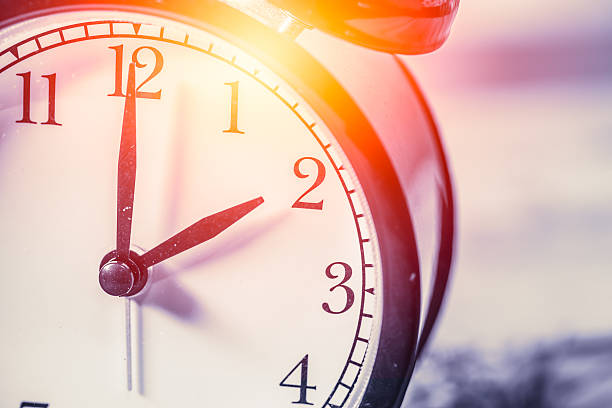 istock closeup vintage clock focus at 2 o'clock with sun light 537249442