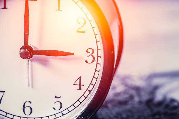 istock closeup vintage clock focus at 3 o'clock with sun light 537249500