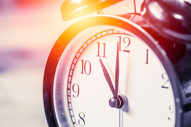 istock closeup vintage clock focus at 11 o'clock with sun light 537250042