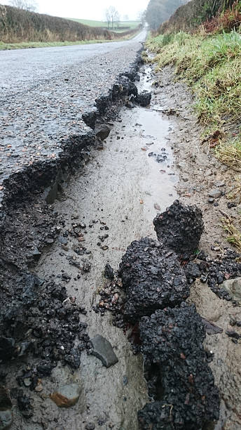 Degraded road edge A degraded road edge with broken tarmac and sharp edges to the verge grass shoulder stock pictures, royalty-free photos & images