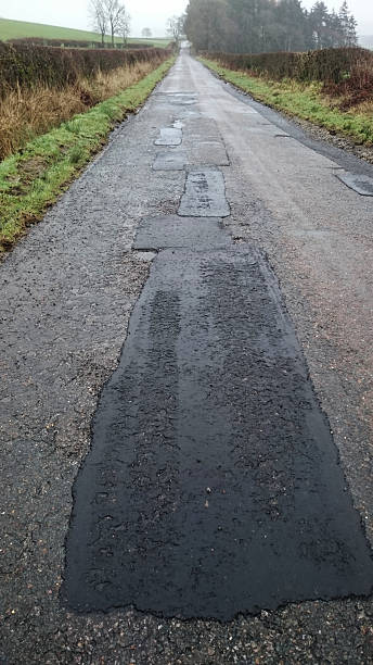 istock Badly repaired road with potholes 537252662