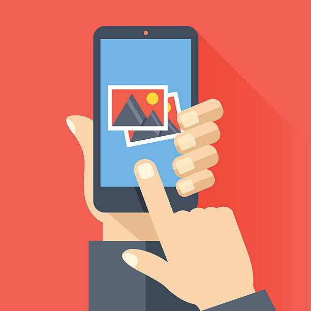 Hand holds smartphone with photos icon. Photo app. Vector illustration Hand holds smartphone with photos icon on smartphone screen. Multimedia, photo album app concept. Modern simple flat design for web banners, web sites, infographics. Creative vector illustration art museum illustrations stock illustrations