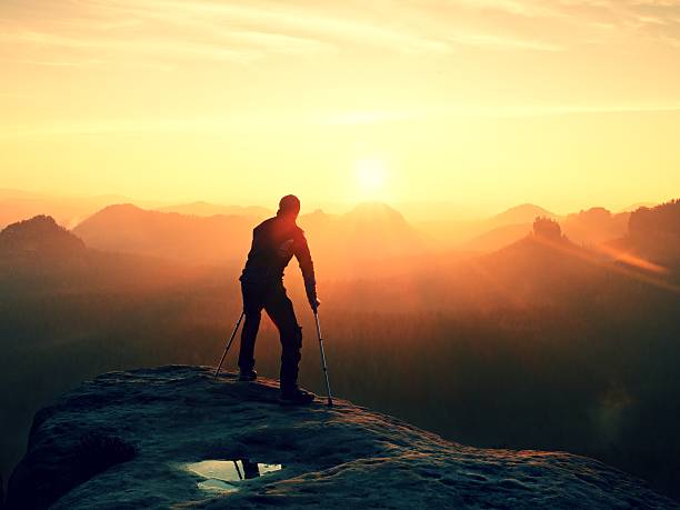 istock Tired hiker with broken leg in immobilizer walk on rock 537254066
