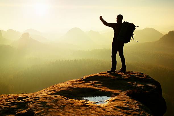 istock Strong hiker taking photo with smartphone, mountain peak 537254756