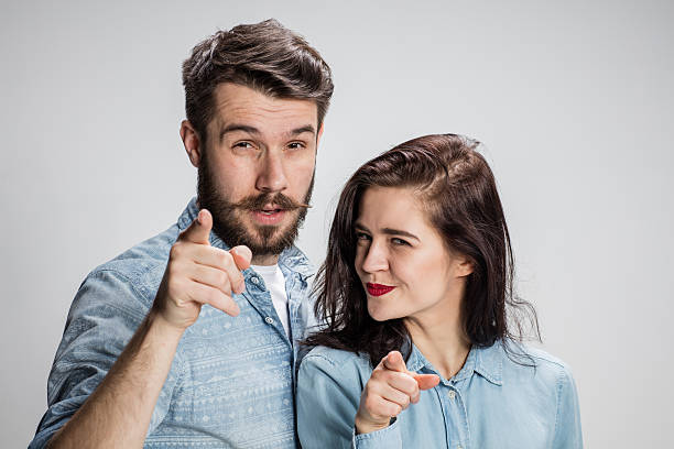 The business man and woman on a gray background The business man and woman on a gray background pointing fingers at the camera sign human hand pointing manual worker stock pictures, royalty-free photos & images