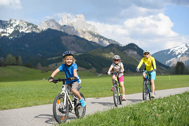 istock Smiling little boy riding bicycle with family 537259220