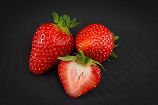 Fresh red strawberry fruit on a dark background
