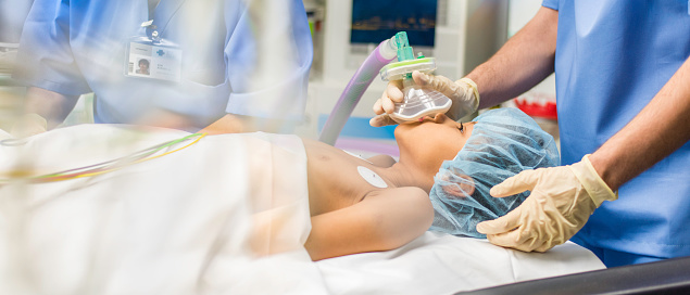 Blurred shot of a child with oxygen mask lying on bed in operating room.
