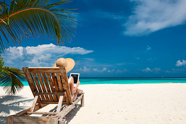 istock Young woman with tablet pc at the beach 537269713