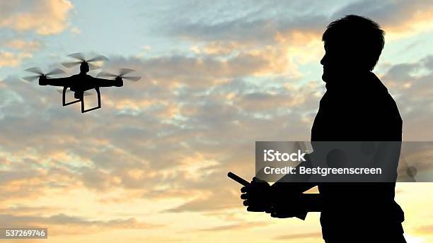 Hombre De Funcionamiento De Volador Soniquete Quadrocopter Al Anochecer Foto de stock y más banco de imágenes de Dron