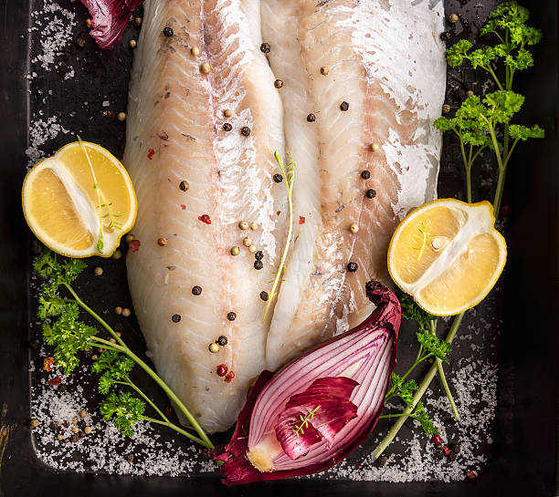 istock Fish fillet on backing tray with lemon, herbs and onion 537270271