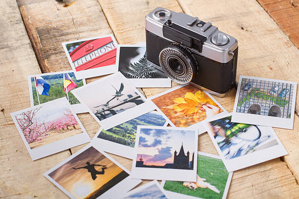istock Old analog camera with real photos over wooden table 537270379