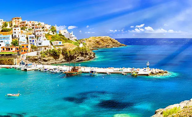 Harbour with marine vessels, boats and lighthouse. Panoramic view from a cliff on a Bay with a beach and architecture Bali - vacation destination resort, with secluded beaches and clear turquoise ocean waters, Rethymno, Crete, Greece
