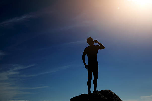 istock Silhouette of runner enjoying sunny day drinking water 537270909