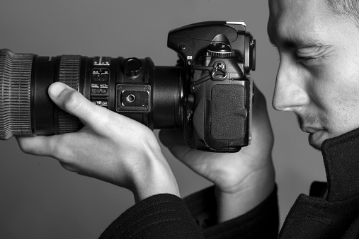 Photographer with a tele objective,side view,black and white.
