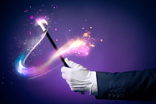 High contrast image of magician hand with magic wand stock photo