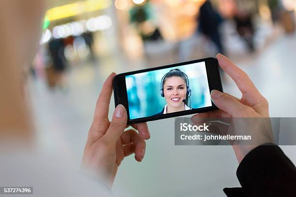 Foto de Mulher Mão Segurando Um Smartphone Durante Um Skype Vídeo e mais fotos de stock de Monitor de computador