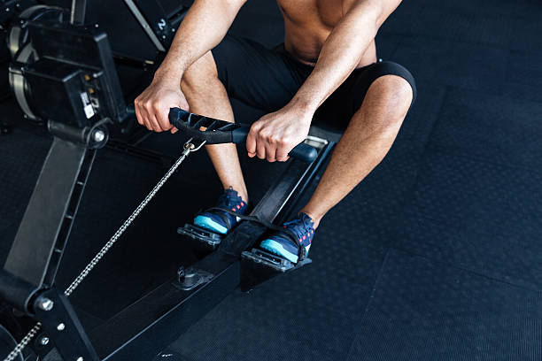 istock Muscular fitness man using rowing machine in the gym 537274776