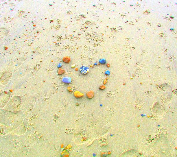 amour forme de cœur de pierres de galets sur la plage de sable-plan - eternity love stone heart shape photos et images de collection