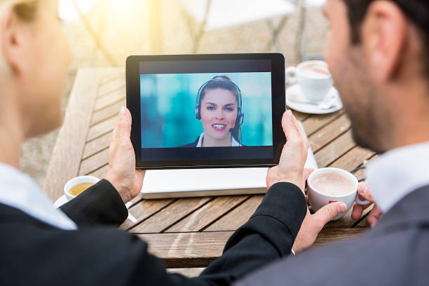 Business people using skype video during a coffee break stock photo