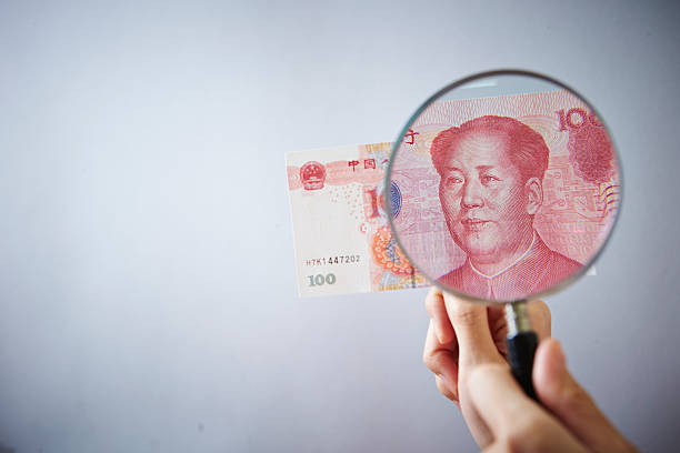 istock Magnifying glass and Chinese RMB bill 537281336