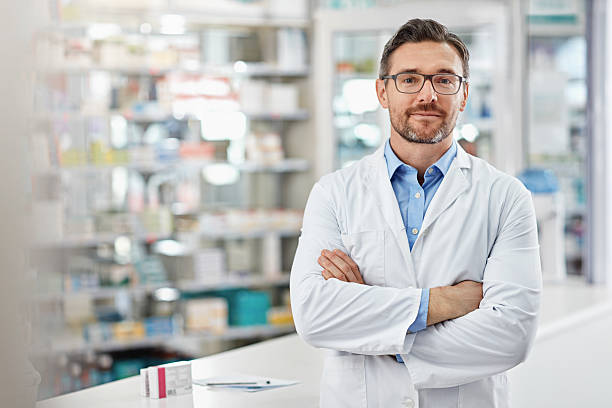 Don’t hesitate to stop by without buying anything Portrait of a pharmacist standing with his arms crossed in a drugstore. All products have been altered to be void of copyright infringements chemist stock pictures, royalty-free photos & images