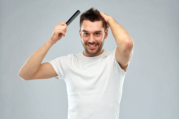 happy man brushing hair with comb over gray