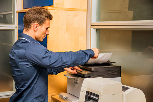 istock Young Man Operating Photocopier Machine 537286685