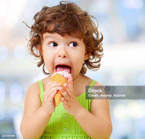 Funy Kid Eating Icecream On Blurred Background Stock Photo - Download Image Now - Child, Eating, Ice Cream