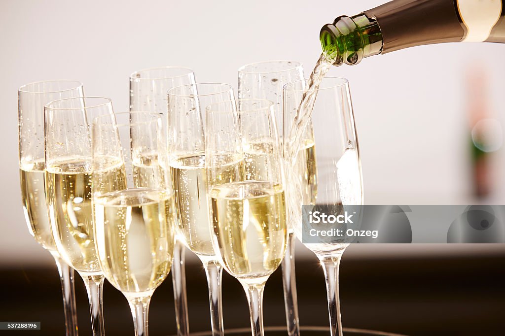 Glasses full of champagne on a tray Champagne drinks being poured on a tray Champagne Stock Photo
