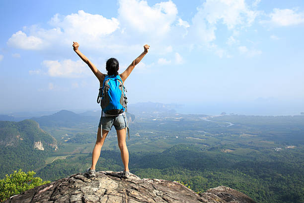istock cheering hiking woman on mountain peak 537289243