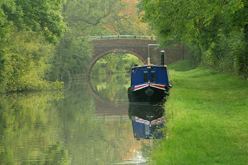 A canal boat moored on a quiet stretch of the Grand Union Canal near Foxton in Leicestershire