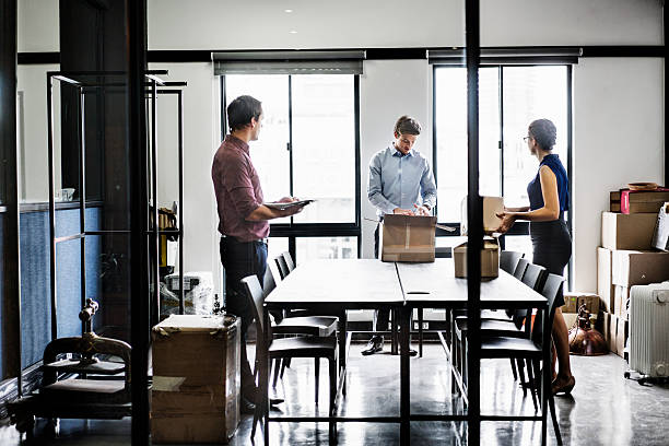 istock Business people with packing boxes in board room 537292290