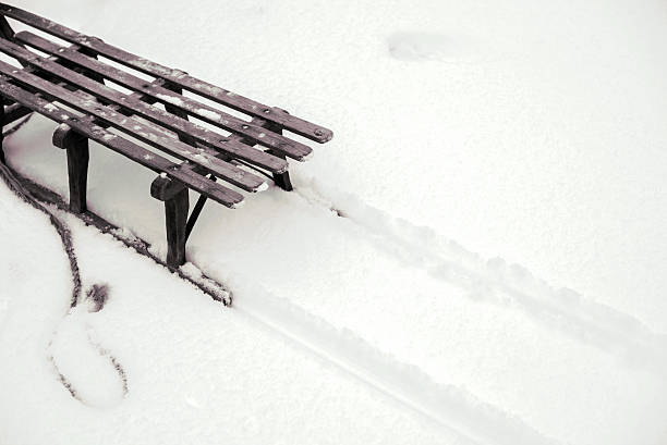 view on the back of old wooden sleigh leaving tracks in the snow