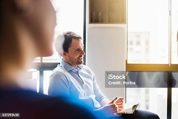 Businessman Sharing Ideas In Meeting Room Stock Photo - Download Image Now - Office, Selective Focus, Brightly Lit