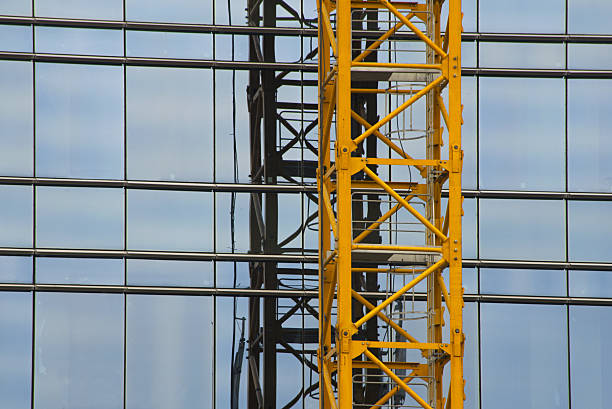 istock yellow crane frame on glass building background 537294192