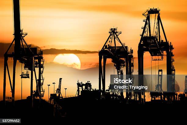 Container Cargo Freight Ship With Working Crane Bridge In Shipyard Stock Photo - Download Image Now